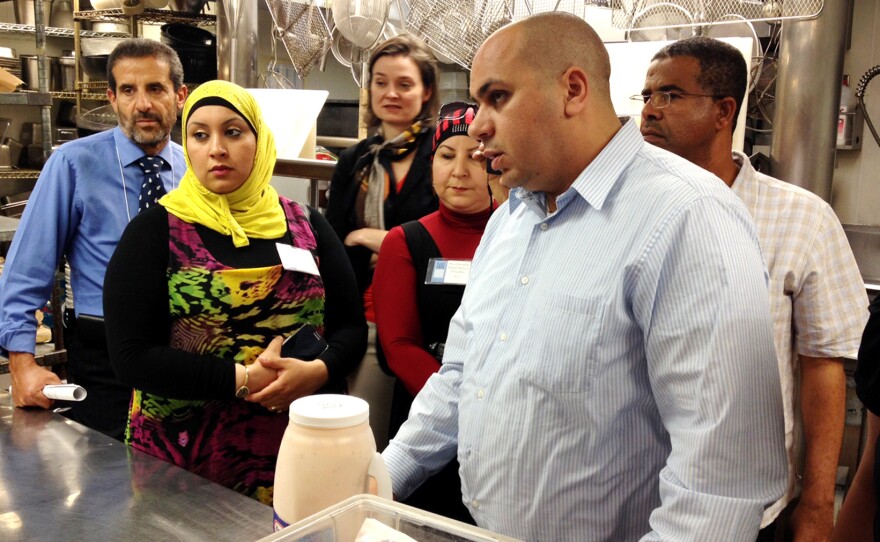 Chefs from Algeria and Oman, along with their translators and local guide, tour the kitchen at Portland's Elephant's Delicatessen.