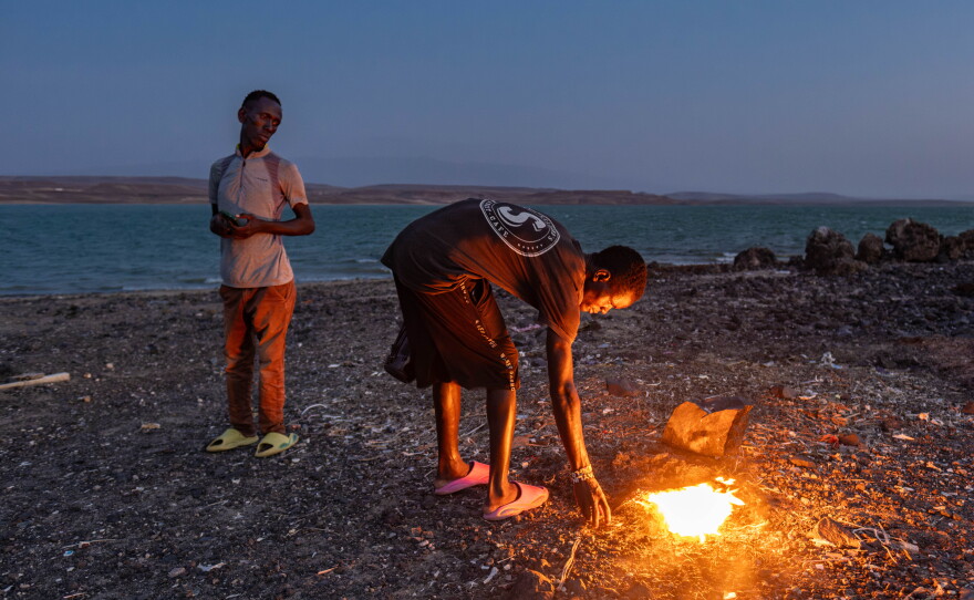 An El Molo youth stokes a fire lit as part of a traditional ritual to bring fish and rain, on Komote Island in Lake Turkana in northern Kenya. Declining fish stocks and flooding have had a huge impact on the El Molo. One of Africa's smallest ethnic groups, they number no more than a few hundred, and their way of life is entirely reliant on the lake.