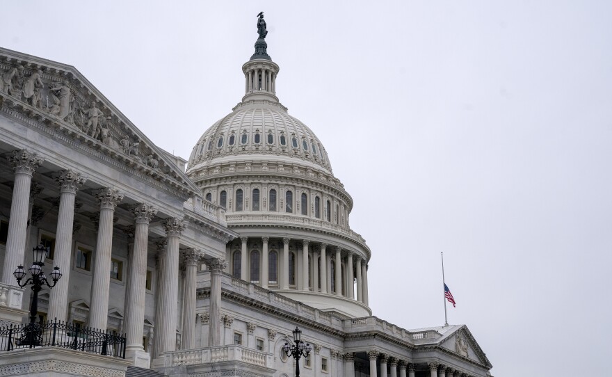 An American flag flies at half staff at the U.S. Capitol on Monday to honor two U.S. Capitol Police officers who died following the violence on Capitol Hill.