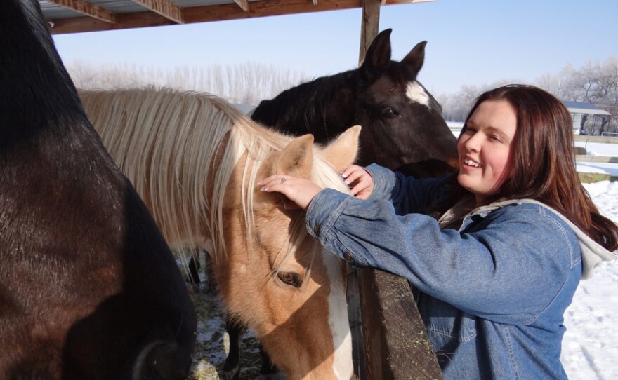 Megan Werhman, former Roy High School student, petting horses at her home in Utah.