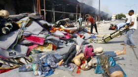 Libyans removed items from a clothes shop Friday after an intense battle in the Abu Salim district of  Tripoli. Hundreds of miles to the east, loyalist troops battled rebels advancing toward the city of Sirte.