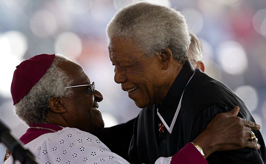 Former South African President Nelson Mandela (right) hugs South African Anglican Archbishop Desmond Tutu at the state funeral for apartheid struggle hero Walter Sisulu in Soweto in 2003.