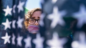 File photo of Emma Rousseau of Oakland, N.J., her mouth bound with a red, white and blue netting, attending a rally on the Fourth of July to protest for abortion rights at Lafayette Park in front of the White House in Washington, Monday, July 4, 2022.