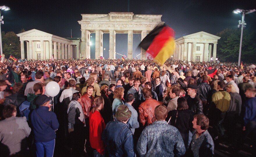 German youths wave flags as they celebrate the country's reunification at the Brandenburg Gate in Berlin in 1990. One Russian lawmaker recently referred to West Germany's "annexation" of East Germany and said it was less legitimate than Russia's "reunification" with Crimea.