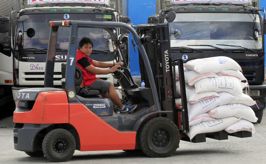 A worker uses a forklift early Saturday to load sacks of rice onto trucks, to be delivered before Typhoon Hagupit makes landfall, inside a Department of Social Welfare and Development warehouse in Manila.