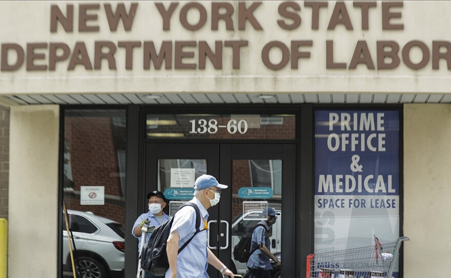 Pedestrians pass a New York State Department of Labor office June 11 in Queens. The Federal Reserve expects the U.S. unemployment rate to still be more than 9% by the end of 2020.