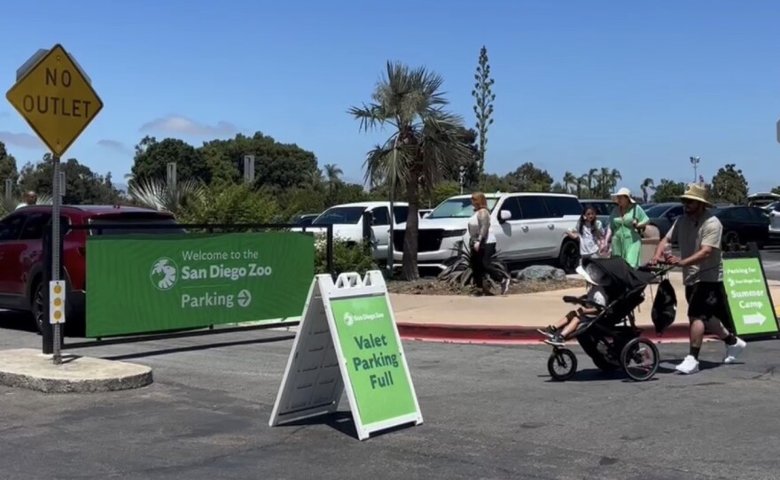 Visitors walk through the parking lot toward the entrance to the San Diego Zoo, July 28, 2025.
