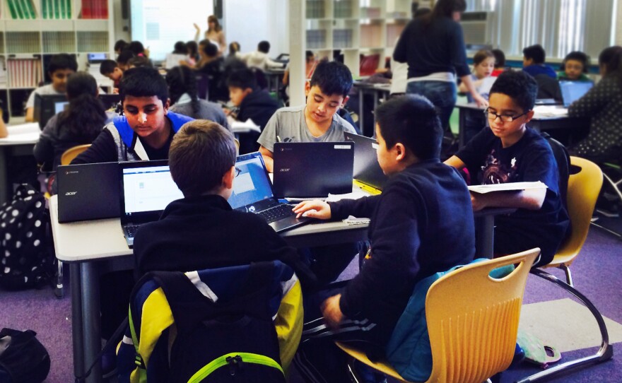 During a "virtual instruction" lesson, students work on their laptops.