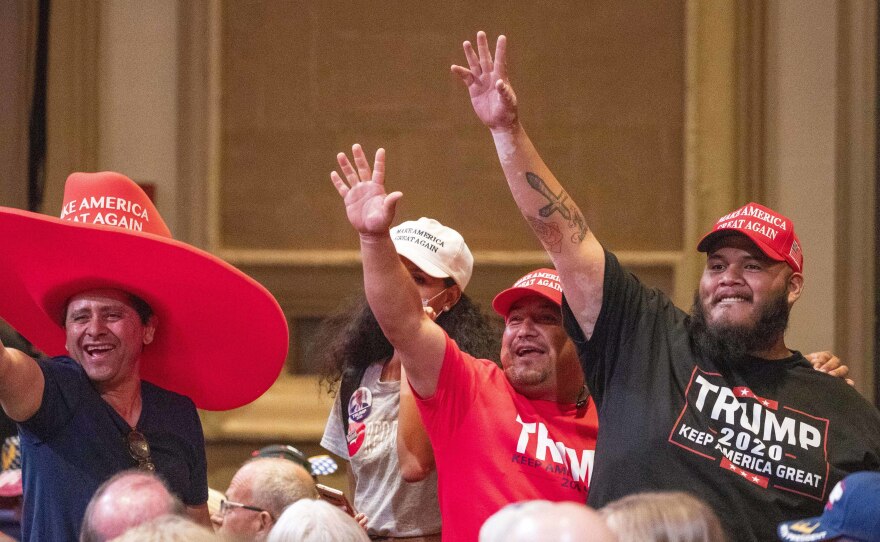 Supporters of President Trump wave during a Latinos for Trump Roundtable at the Arizona Grand Resort in Phoenix on Sept. 14.