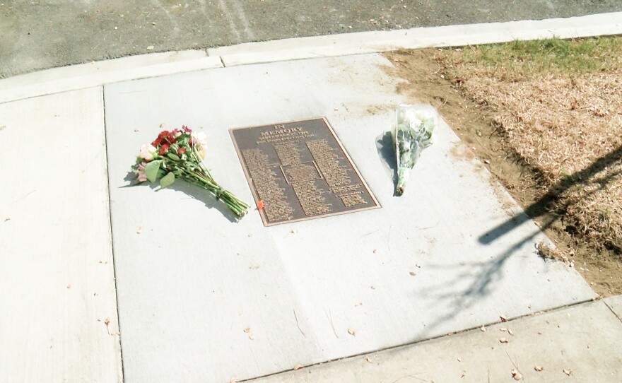A new memorial plaque with the names of all 144 victims of the PSA Flight 182 crash is shown at the intersection of Dwight and Nile streets in North Park.  Flowers are shown next to the plaque on Sept. 25, 2024.