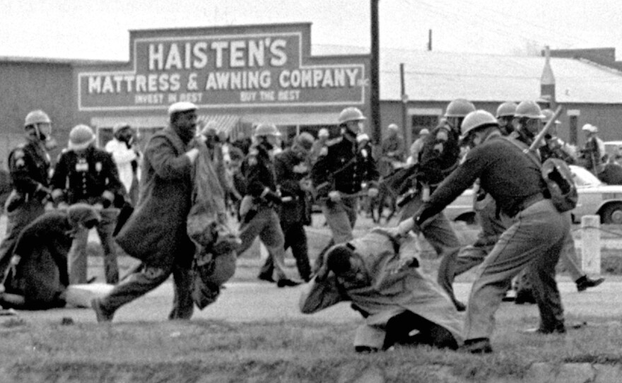 In this March 7, 1965, file photo, state troopers use clubs against participants of a civil rights voting march in Selma, Ala.