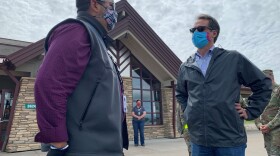 Montana Gov. Steve Bullock, right, gets an update on coronavirus testing from councilman Martin Charlo of Confederated Salish and Kootenai tribes. Montana now has the lowest coronavirus infection rate in the U.S.
