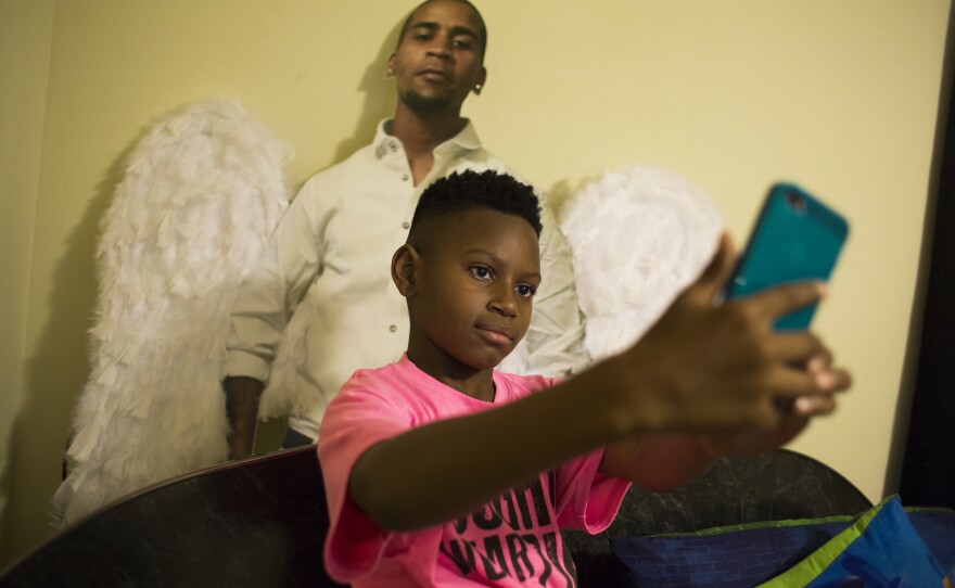 A few weeks after Javon Johnigan's shooting death on Sept. 3, 2016, his 8-year-old son Jamai demonstrates how he takes selfies with a life-size cutout of his father. Originally made for the funeral and the repast, Jamai keeps the cutout of his dad behind his bed. "We talk to him and take pictures with him," said Javon's mother, Elizabeth Johnigan. "It's a big help for someone who is grieving."