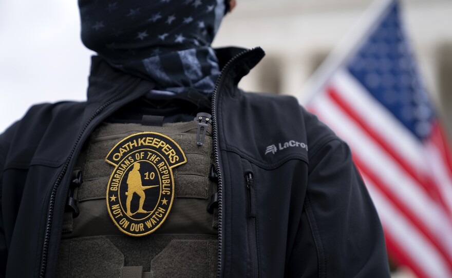 A demonstrator wears a badge for the extremist group the Oath Keepers on a protective vest during a protest outside the Supreme Court in Washington, D.C., on Jan. 5, 2021.