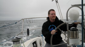 Sailor Matt Rutherford at the helm of a sailboat. He hopes to be the first to circumnavigate the Arctic Circle alone.