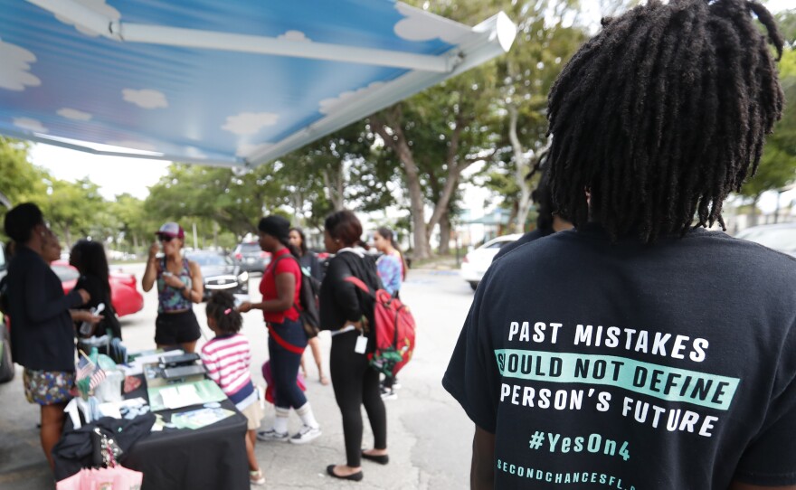 People gather around the Ben & Jerry's "Yes on 4" truck as they learn about Amendment 4 in Miami, which passed election day. Now, Gov.-Elect Ron DeSantis says he and state lawmakers will need to weigh-in before the amendment goes into effect, giving voting rights back to most felons in the state.