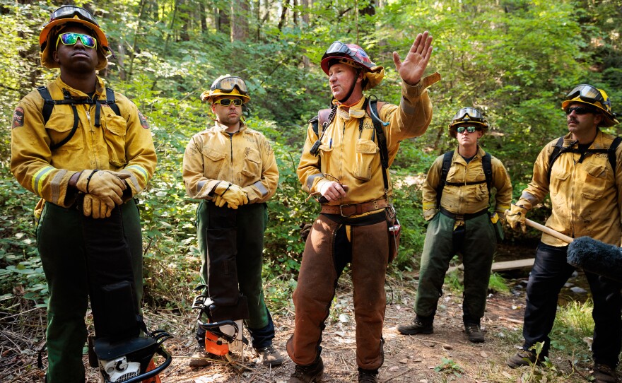 Cal Fire Captain Eric Ayers briefs members of the California National Guard's Task Force Rattlesnake before they spend the day clearing brush and small trees, all part of fire prevention tactics.