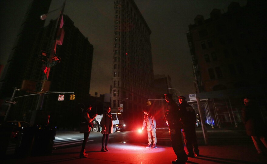 A road flare became an impromptu flashlight in front of a darkened Flatiron Building in Manhattan during a blackout following Hurricane Sandy in 2012.