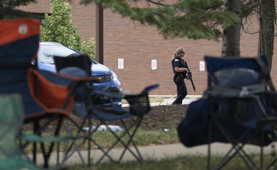 An armed law enforcment officer patrols the scene of the July 4th parade shooting in Highland Park, Illinois on Monday.