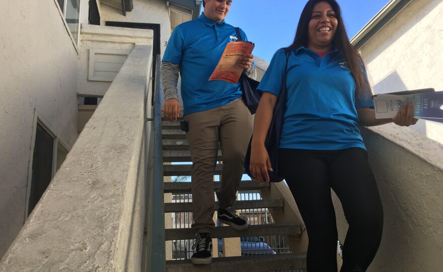 Dennis Smith, 18 (left), and Rosa Olascoaga Vidal, 22, descend the stairs of an apartment complex where they contacted a voter, Nov. 5, 2018.