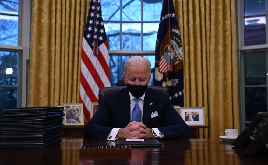 President Biden sits in the Oval Office at the White House after being sworn in as the 46th president of the United States on Wednesday.
