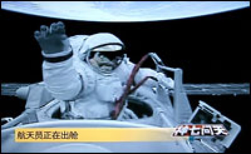 A screen shot from CCTV (China Central Television) shows Chinese astronaut Zhai Zhigang waving while walking out of the capsule of the Shenzhou VII, on Saturday.