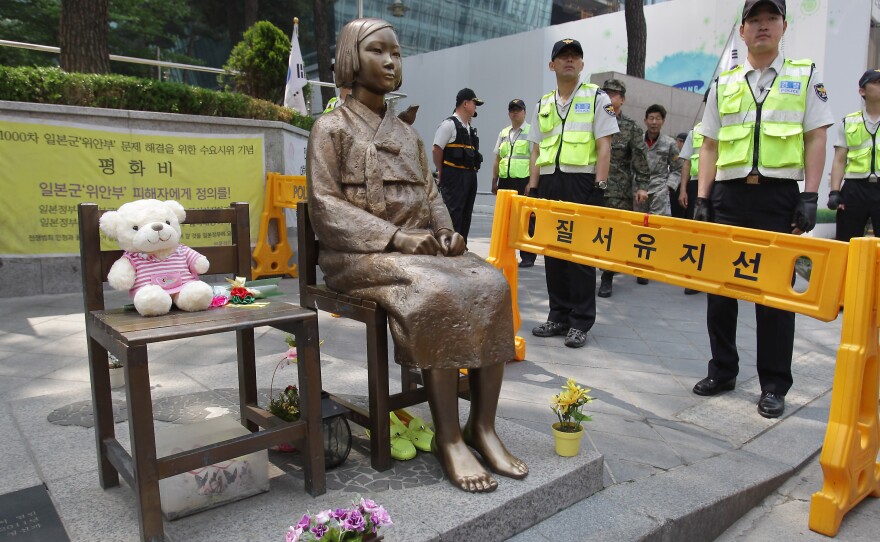 South Korean police stand guard beside a comfort woman statue in front of the Japanese embassy in Seoul in May. The Southern California city of Glendale will dedicate an identical statue on Tuesday.