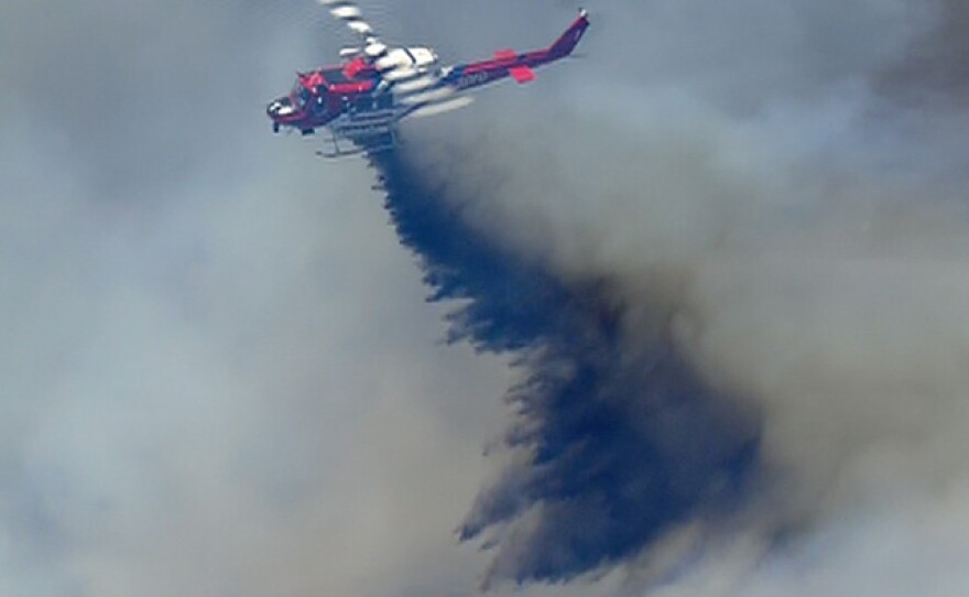 A helicopter drops retardant on a brush fire near 4S Ranch, May 13, 2014.