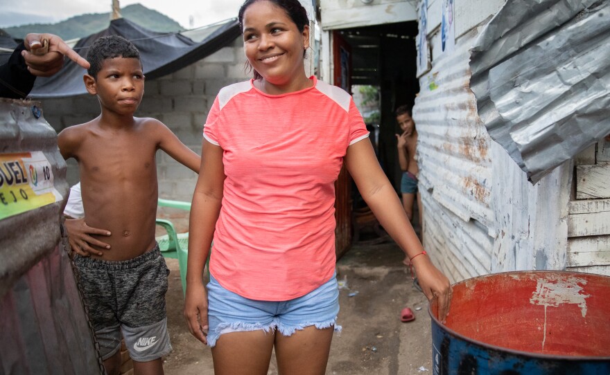 In La Paz, a low-income neighborhood on the outskirts of Santa Marta, Colombia, water service from the local utility can be erratic or nonexistent. Pictured: Neighborhood kids stand next to a rain barrel positioned under a corrugated roof.