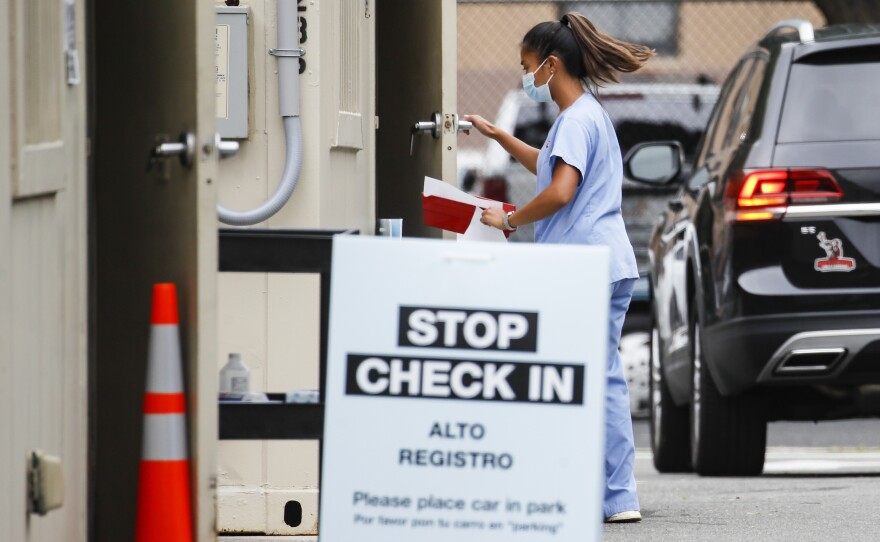 Six states have an agreement to acquire fast-result antigen tests for COVID-19. Pictured is a medical worker collecting a sample from a patient.