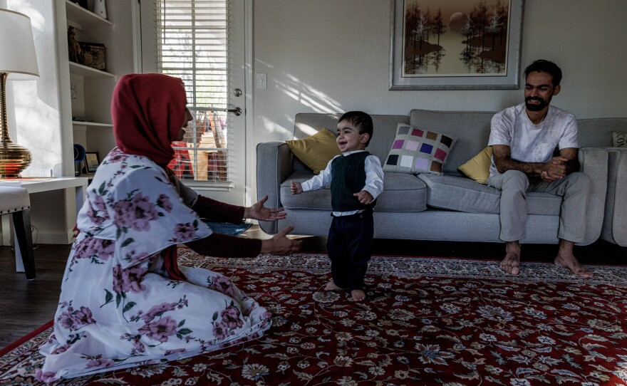 Afghan helicopter pilot Rashid Ahmad Muslim, 25, with his wife, Nasrin Halimi, 22, who is three months pregnant, and their son Mohammad, 14 months, in their home in Chandler, Ariz., on Dec. 11, 2022.