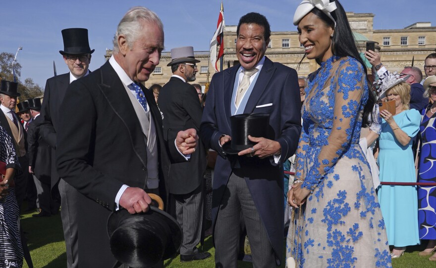 King Charles III laughs with American singer Lionel Richie and his girlfriend, Lisa Parigi, during a Wednesday garden party at Buckingham Palace in celebration of Saturday's coronation. Richie is among those performing at Sunday's Coronation Concert.