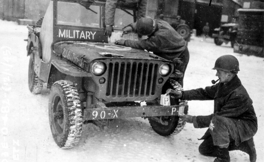 This photo provided by the Ghost Army Legacy Project shows soldiers putting new bumper markings a jeep, one of the special effects the units used towards the end of WWII to trick German troops and save American lives.