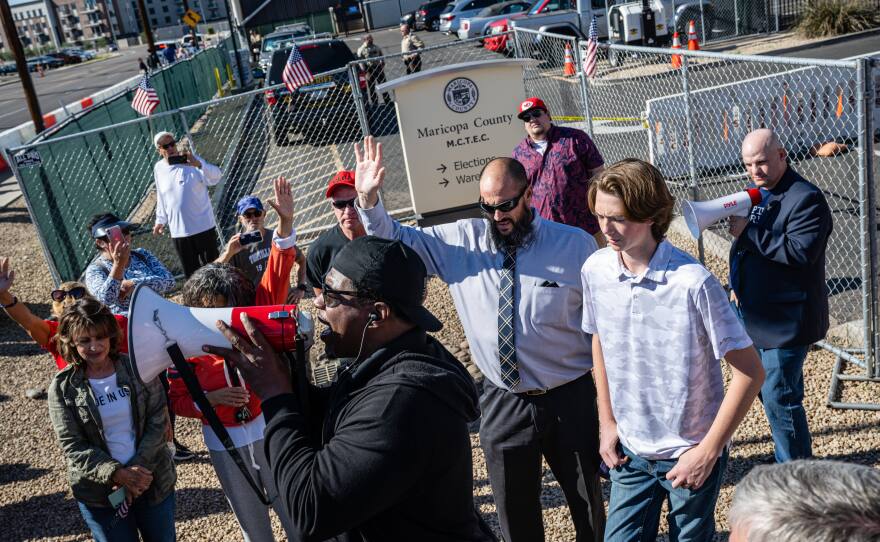 Right-wing activists protest the election process in front of the Maricopa County election center in Phoenix on Saturday. Ballots continue to be counted there as officials push back against conspiracy theories claiming the process is being delayed.