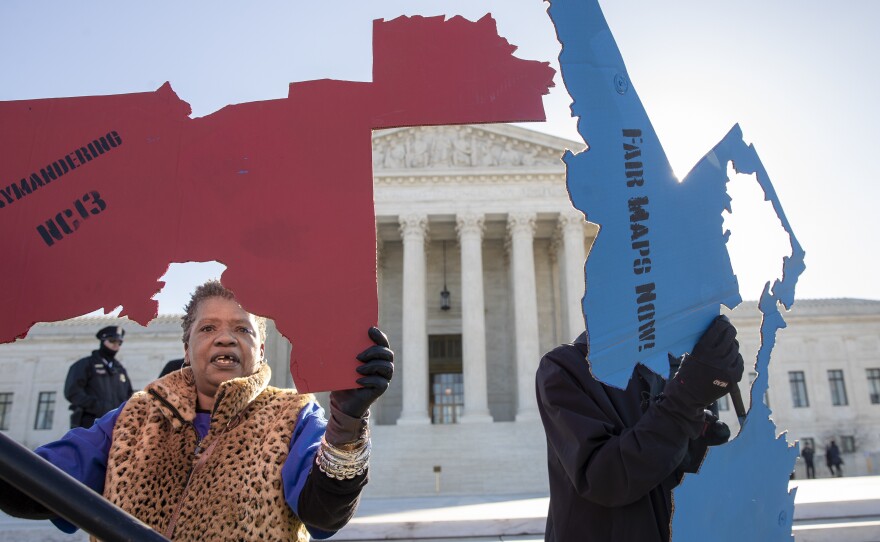 Activists opposed to partisan gerrymandering hold up representations of congressional districts from North Carolina, left, and Maryland, right, ahead of Supreme Court arguments last spring. The court ultimately decided that federal courts could not adjudicate partisan gerrymandering cases.