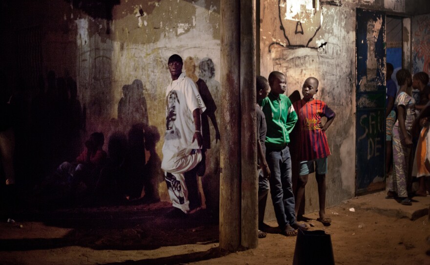 Alassane "Khohk" Kadia (left) shakes off pre-show jitters before performing on the sandy streets of a neighborhood in Dakar. Below: Carre D'as practices at the Africulturban community center.