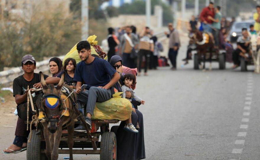 Palestinians arrive south of Gaza City on Sunday after fleeing their homes amid the ongoing battles between Israel and the militant group Hamas.