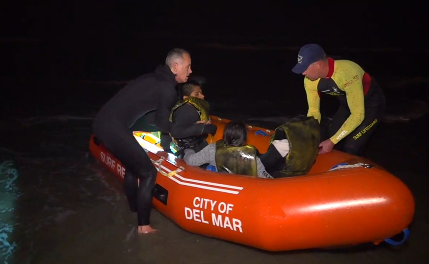 Rescuers help passengers from a lifeguard boat in Del Mar after a smuggling boat unloaded over a dozen people off the Del Mar coast, Feb. 28, 2020.