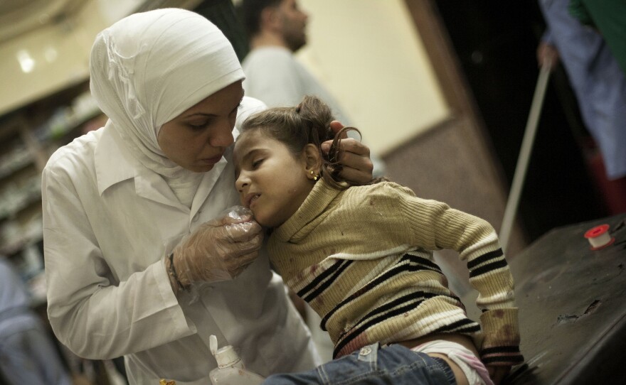 In a photo from October 2012, a nurse treats a girl wounded by Syrian Army artillery shelling at Dar El Shifa hospital in Aleppo, Syria.