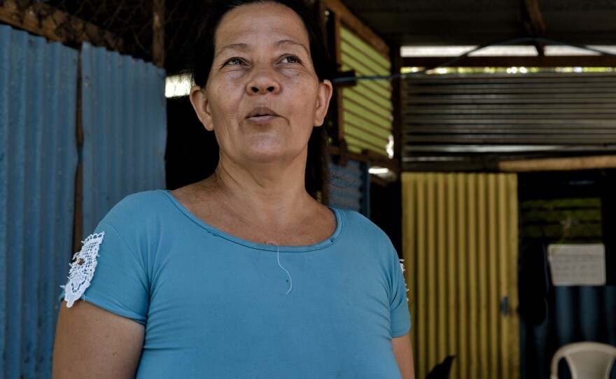 María del Carmen Aguirre talks about the advantages of using bitcoin and a digital wallet for her business, a convenience store which has her name, in El Zonte beach town.