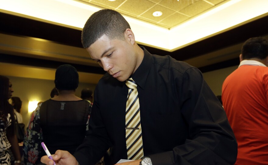 In this photo taken in July, Gustavo Monteagudo fills out a job application at a job fair in Miami Lakes, Fla. The U.S. unemployment rate dipped to a seven-year low for August, to just 5.1 percent.