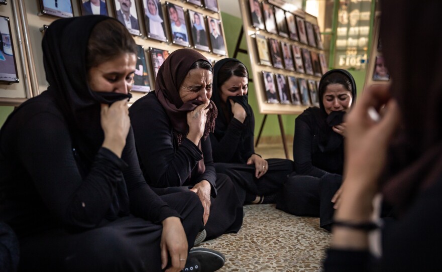 Women from Kocho weep for the victims of the genocide. Convoys of ISIS fighters invaded the Sinjar region, intent on eradicating Yazidi religion. Kurdish security forces in charge of the region retreated, leaving the Yazidis defenseless.