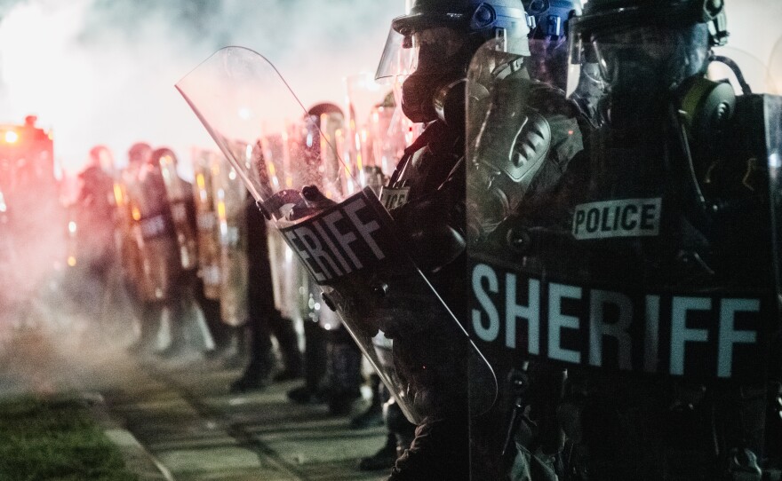 Law enforcement hold a line on Aug. 25, 2020 in Kenosha, Wis. The union representing police officers in Kenosha say Jacob Blake, who was shot multiple times at close range and severely wounded by a police officer Sunday, was armed with a knife.