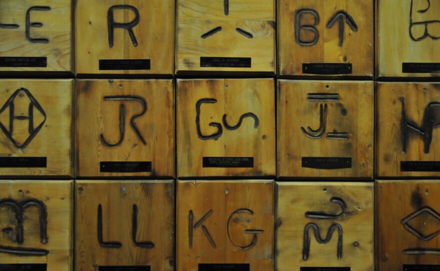 Brands from ranches around Oklahoma hang on the wall at OKC West Livestock Market in El Reno, Okla.
