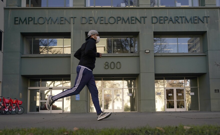 Above, a runner passes the office of California's Employment Development Department in Sacramento in December 2020.