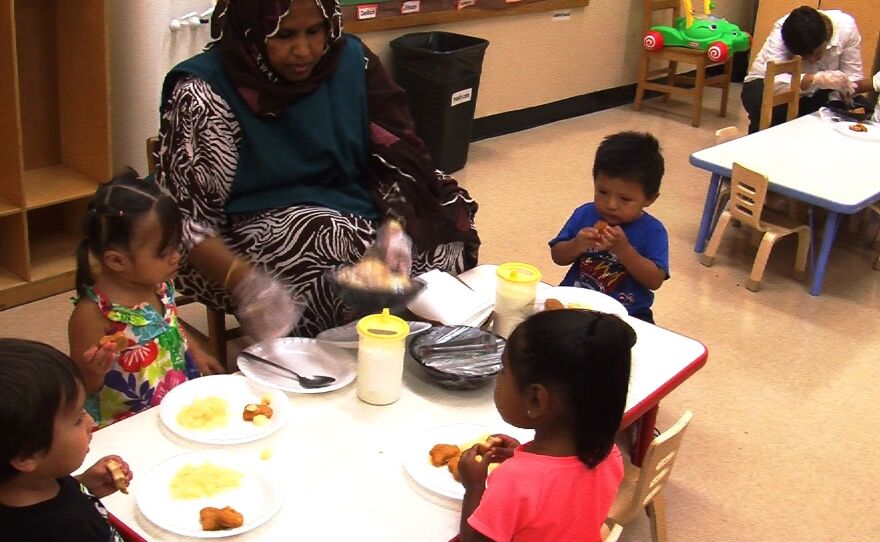 A preschool worker at Lindsay School serves lunch to children of teen mothers who attend the school, Aug. 15, 2014.