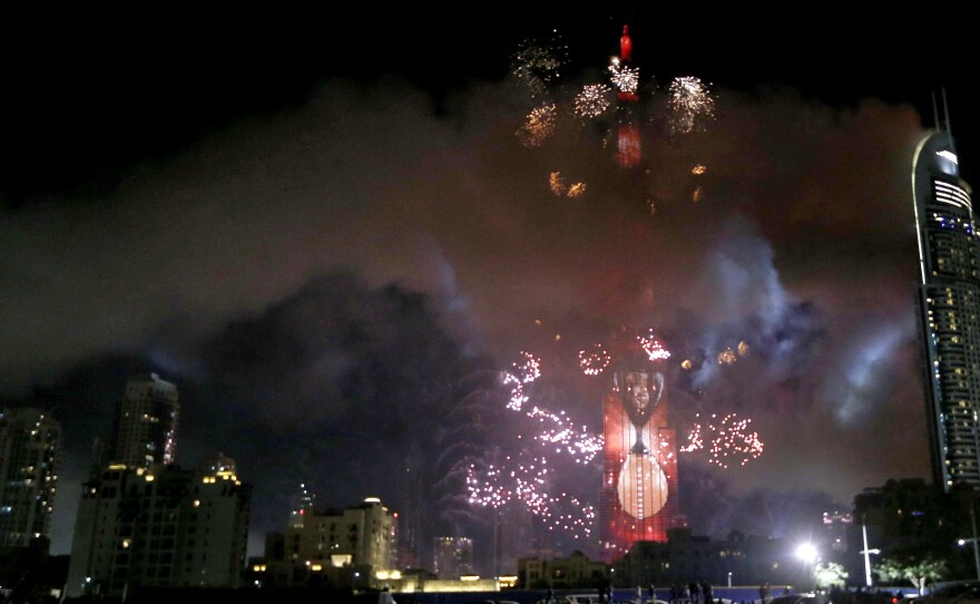 Smoke billows from the Address Downtown Hotel, at right, after it caught on fire hours earlier, as a fireworks display goes off near the Burj Khalifa in Dubai on Friday.