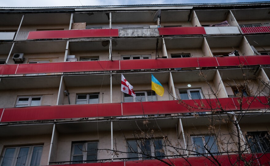 A Ukranian flag and a Georgian flag wave outside a residential building in Gori, across the street from the Stalin museum.