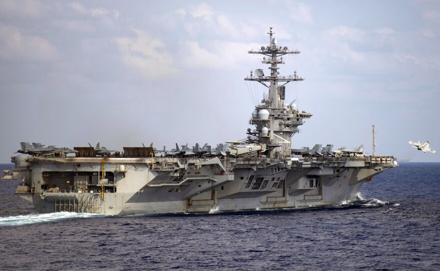 The aircraft carrier USS Theodore Roosevelt is in the western North Pacific Ocean on March 18. The Navy has recommended reinstatement of the ship's captain who was fired after pleading for help with the coronavirus infection onboard.