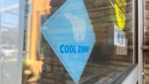 A sign that says "Cool Zone" hangs in the window of the San Marcos Library on July 31, 2026.